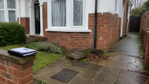 Southampton home exterior with damp paving, inspection chamber and drainage access showing possible house survey drainage concerns.